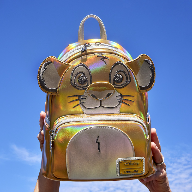 Two hands holding the Disney100 Platinum Simba Mini Backpack up in the air 